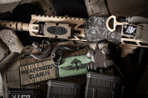 Close-up of SILYNX Clarus 1 and tactical gear with 'Weaponized Clarus' patch on a dark background