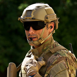 Soldier with helmet and sunglasses wearing Silynx Boom Microphone, earpiece and Clarus control box.
