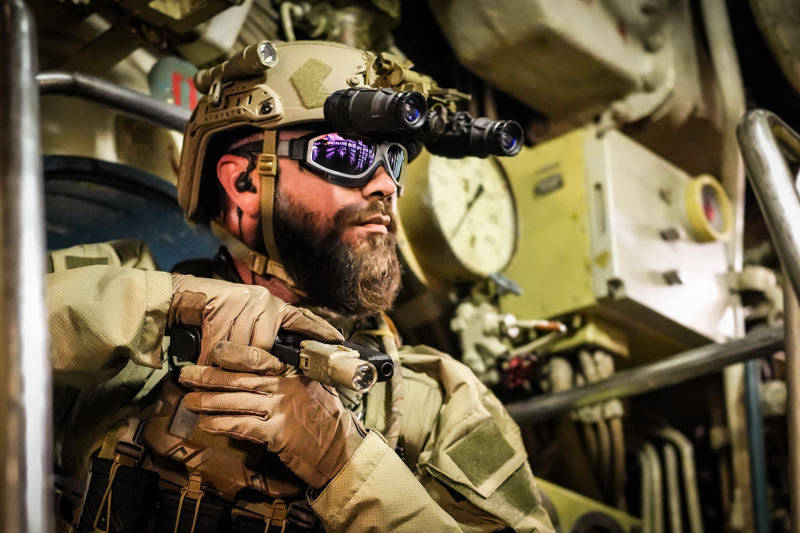 Soldier in military gear inside a submarine, wearing Silynx Protego Headset, goggles and gloves.