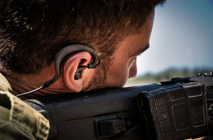 Soldier wearing Silynx protego headset while holding a rifle.