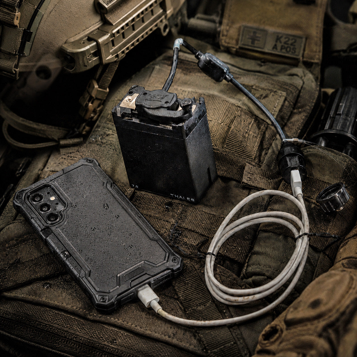 Silynx MBITR USB smartphone battery charger. Phone case with battery pack and cable on tactical gear