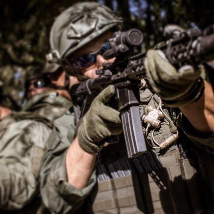 Soldier in tactical gear holding a rifle with a scope using silynx clarus I in a forest setting