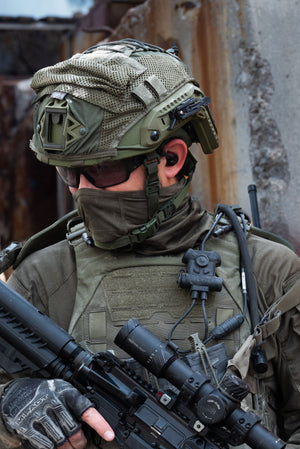Soldier in tactical gear holding a rifle with Silynx Clarus II,  a helmet and face mask in an urban setting