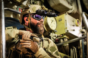 Soldier in military gear inside a submarine, wearing Silynx Protego Headset,  goggles and gloves.
