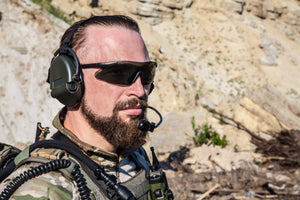 Soldier in tactical gear with Silynx Protego SDR communication equipment in a rocky outdoor setting