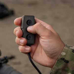 Hand holding Silynx Bluetooth dongle with a blurred background